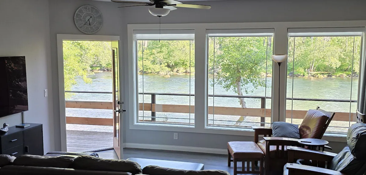 Living room has big picture windows & door to deck